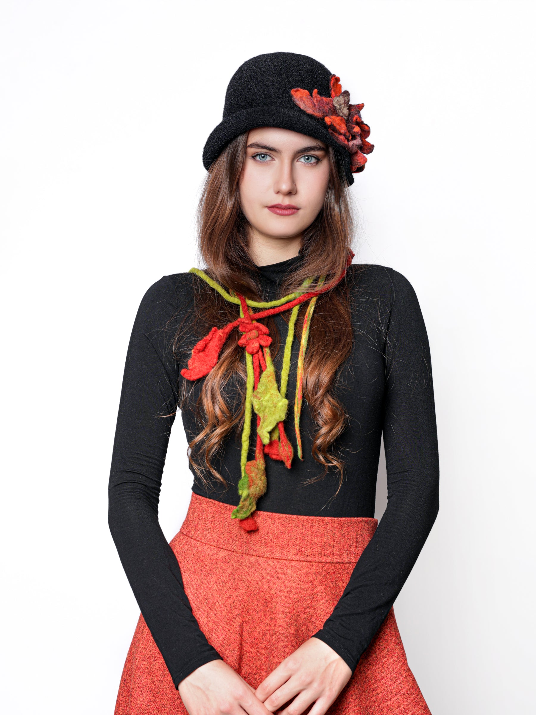 Woman wearing a multicolor wool neckpiece with green and red floral details, styled as a statement fashion accessory.