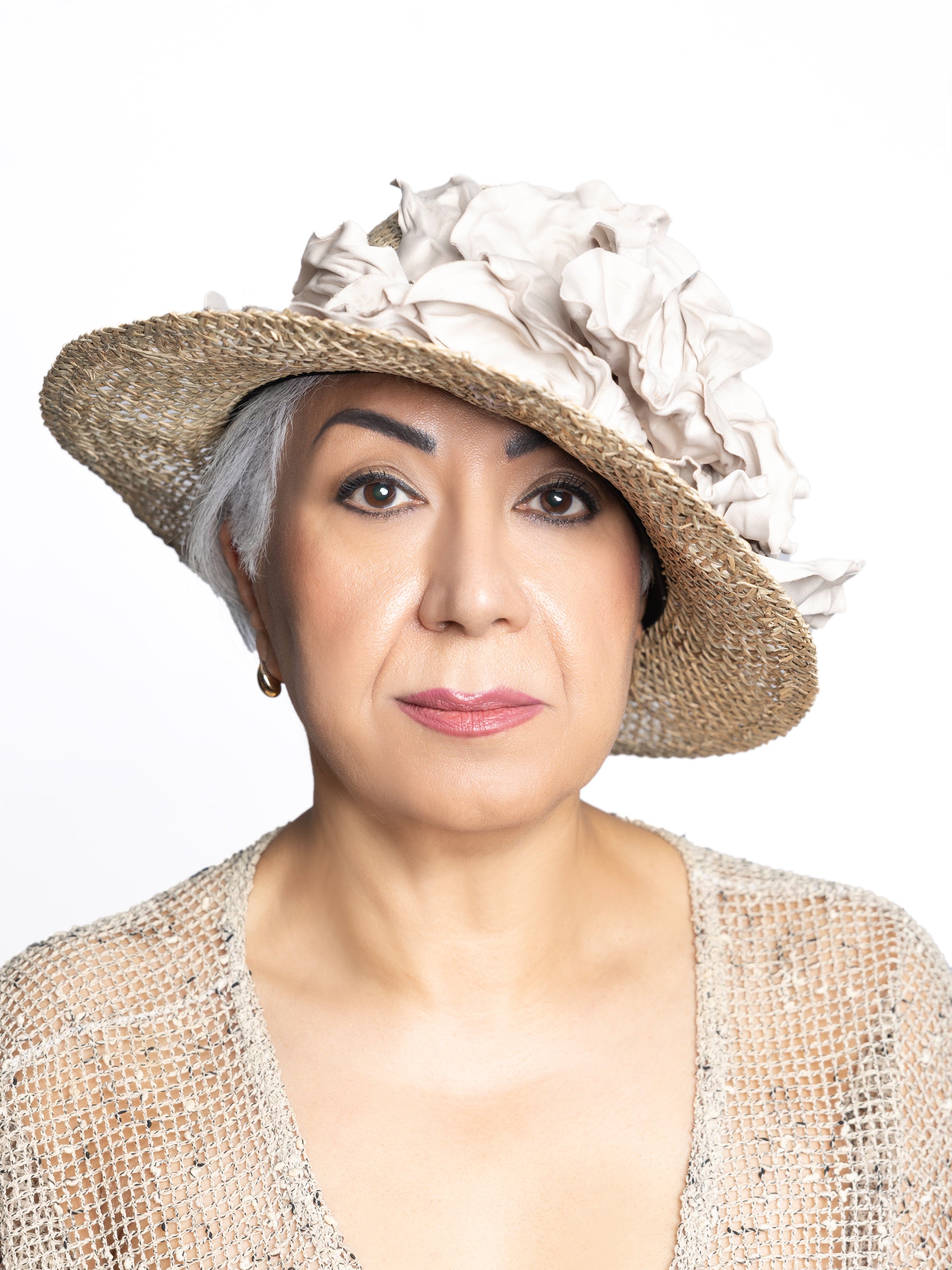 Woman wearing a handcrafted natural straw sun hat with an ivory satin flower.