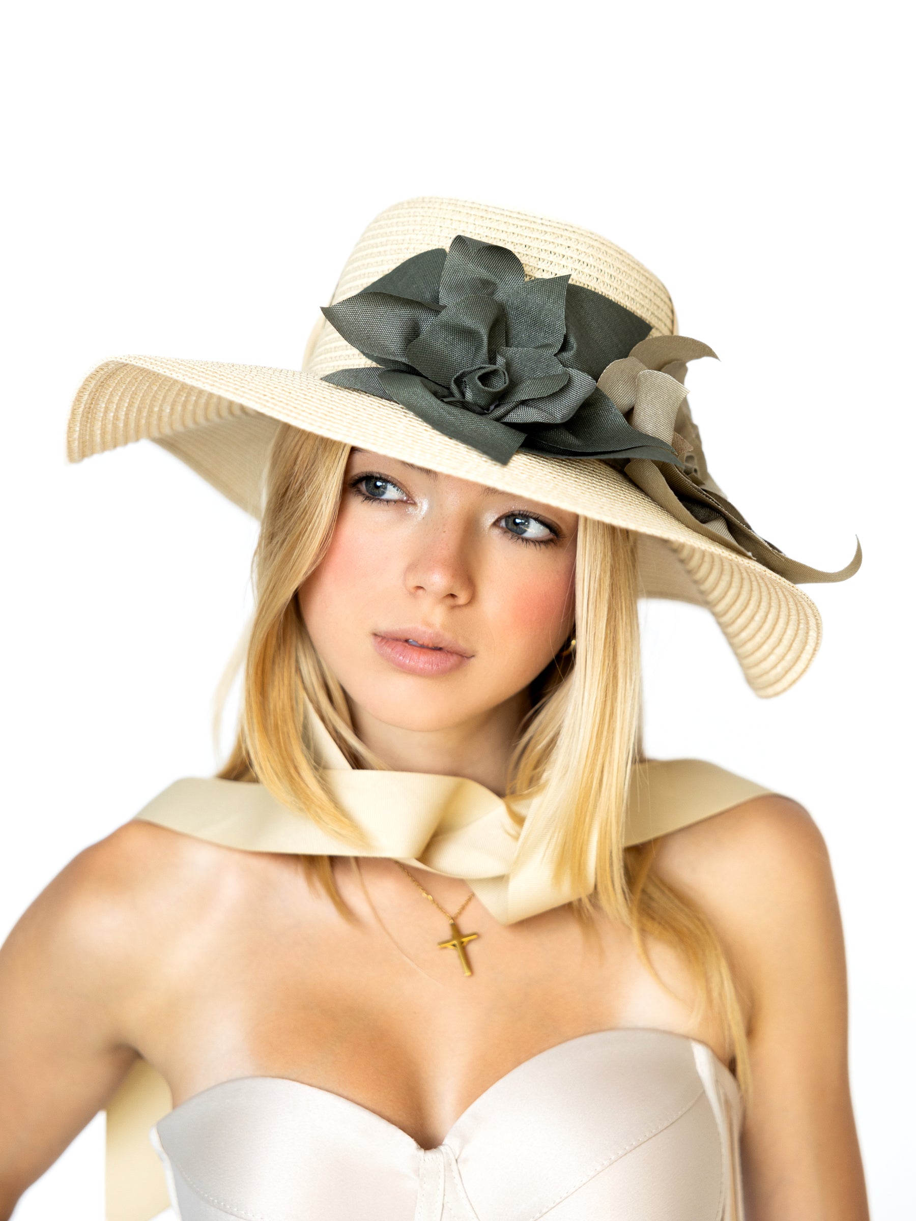 Close-up view of a straw summer hat featuring olive green satin flower embellishments.