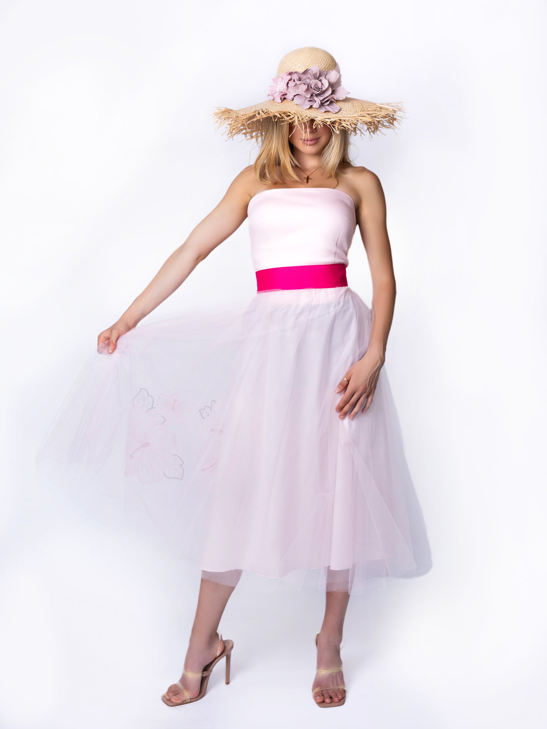 Full-length view of a model wearing a wide-brim straw summer hat as a statement accessory.