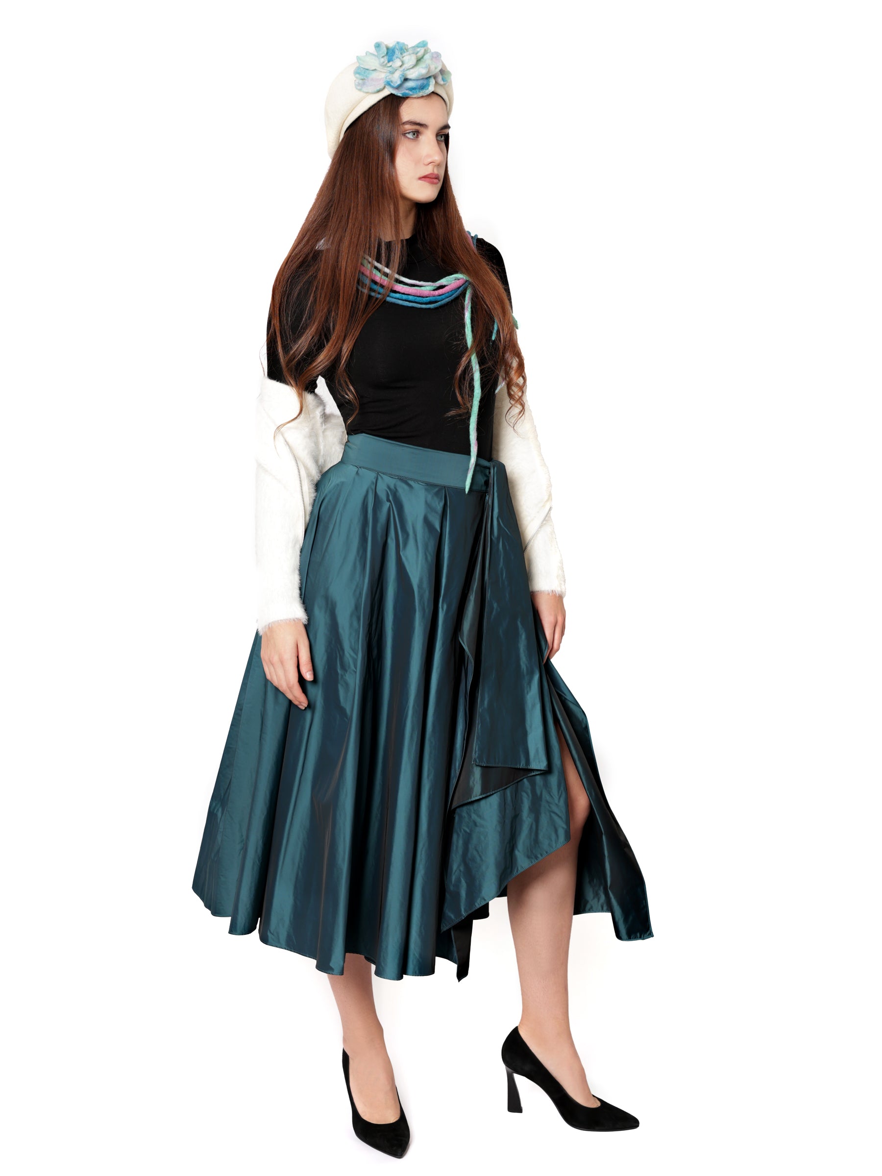 Female model wearing a handcrafted teal blue skirt shown from the side, highlighting its flowing silhouette.