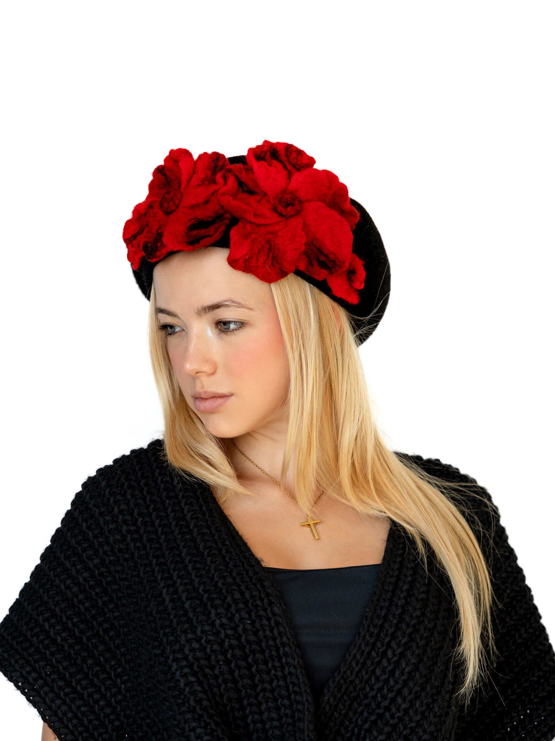 Model wearing a black wool beret hat with handmade red felt floral detail, facing right.