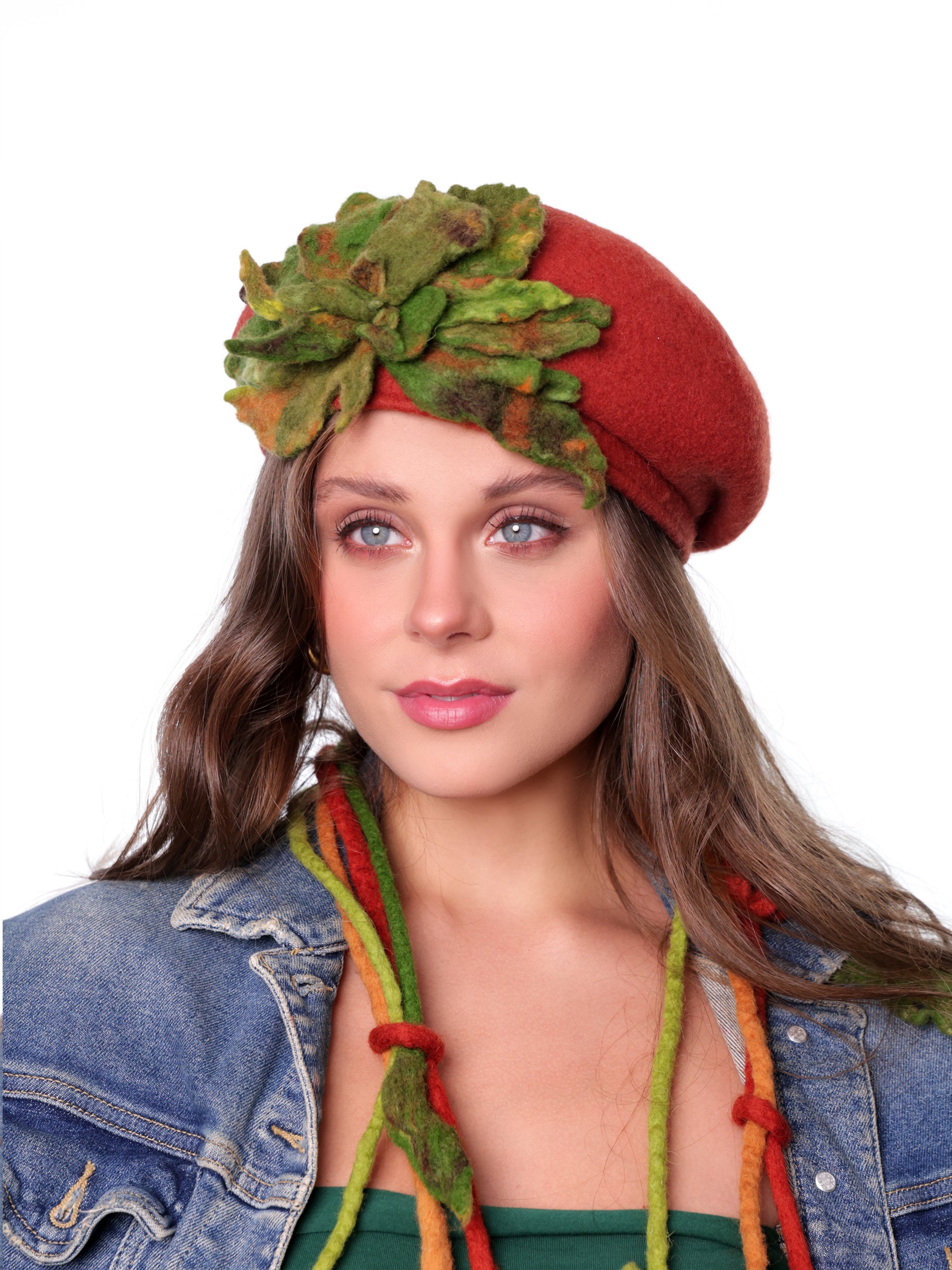 Front view of a wool winter beret hat featuring a multitone green felt flower on a red base.