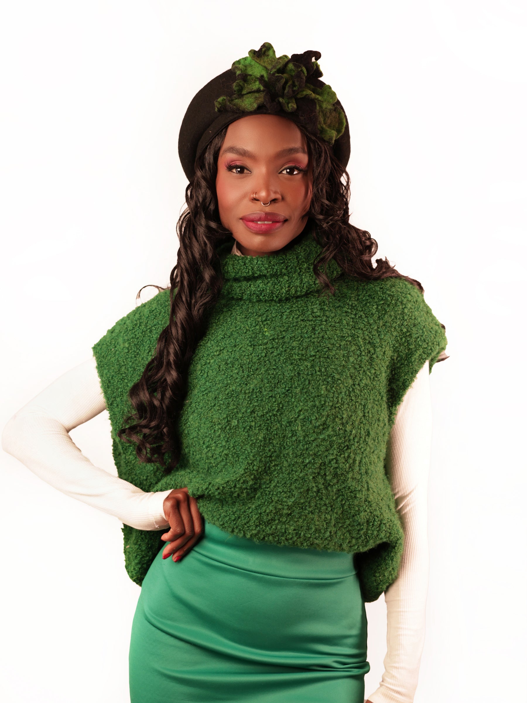 Full view of black wool beret hat with green anthurium-inspired felt flower, model facing camera, handcrafted winter beret.