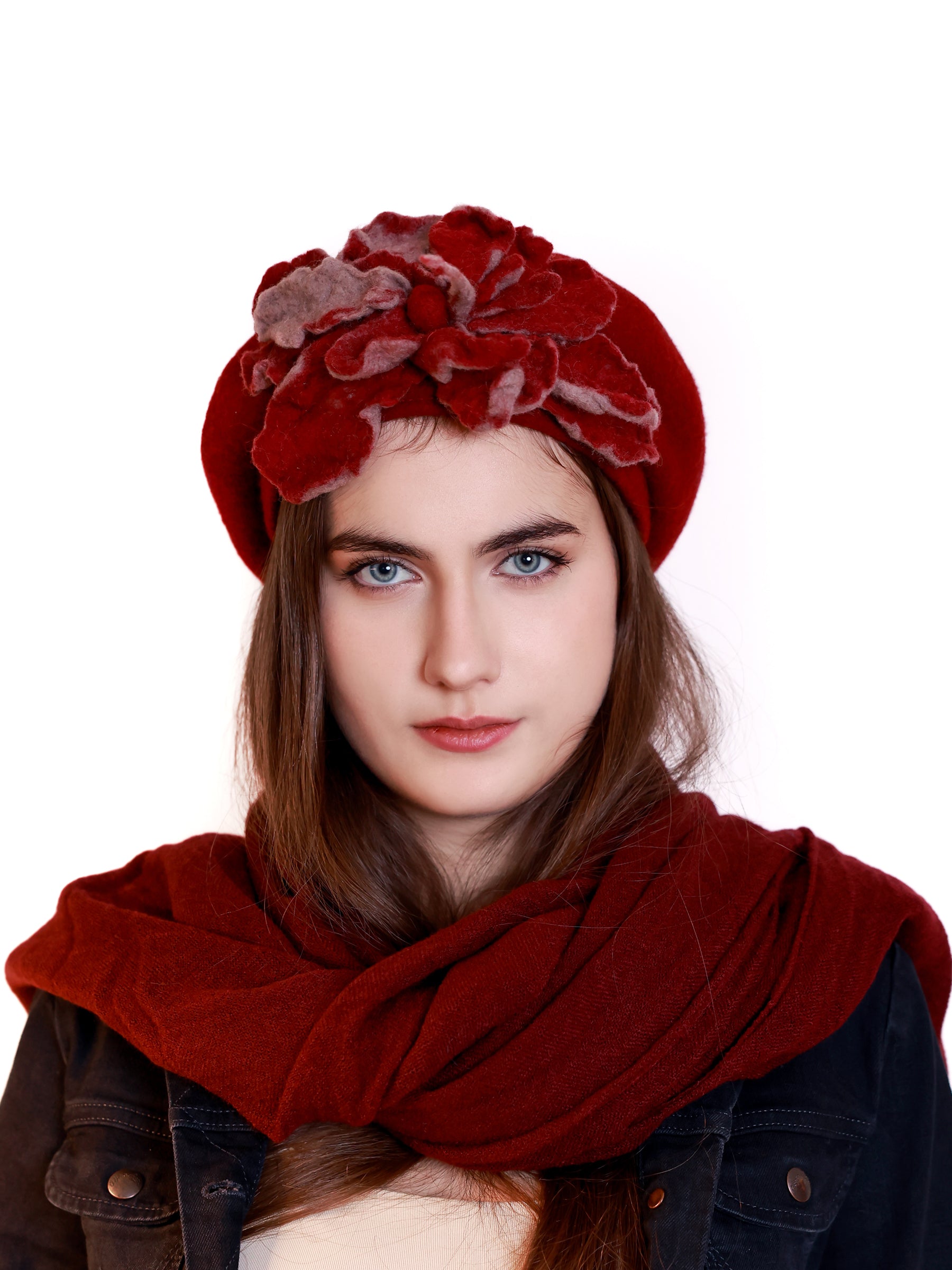 Woman wearing a red wool beret with layered handmade floral details in red tones.