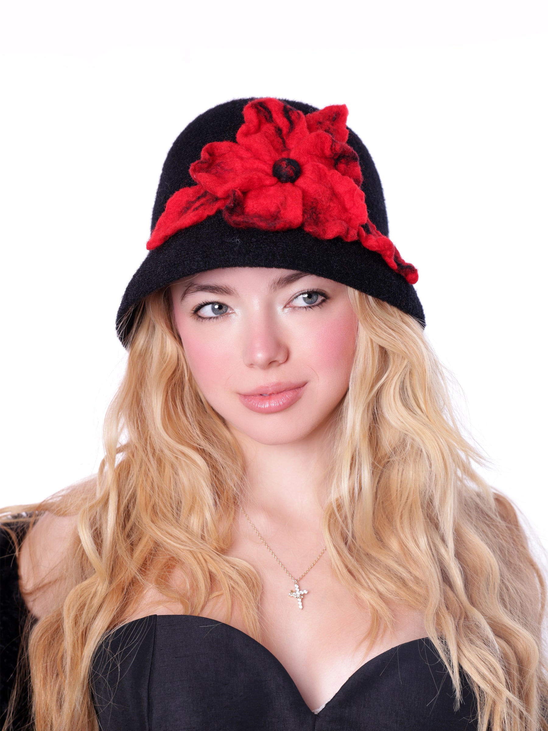 Woman wearing a handcrafted black cloche hat with a bold crimson wool flower.