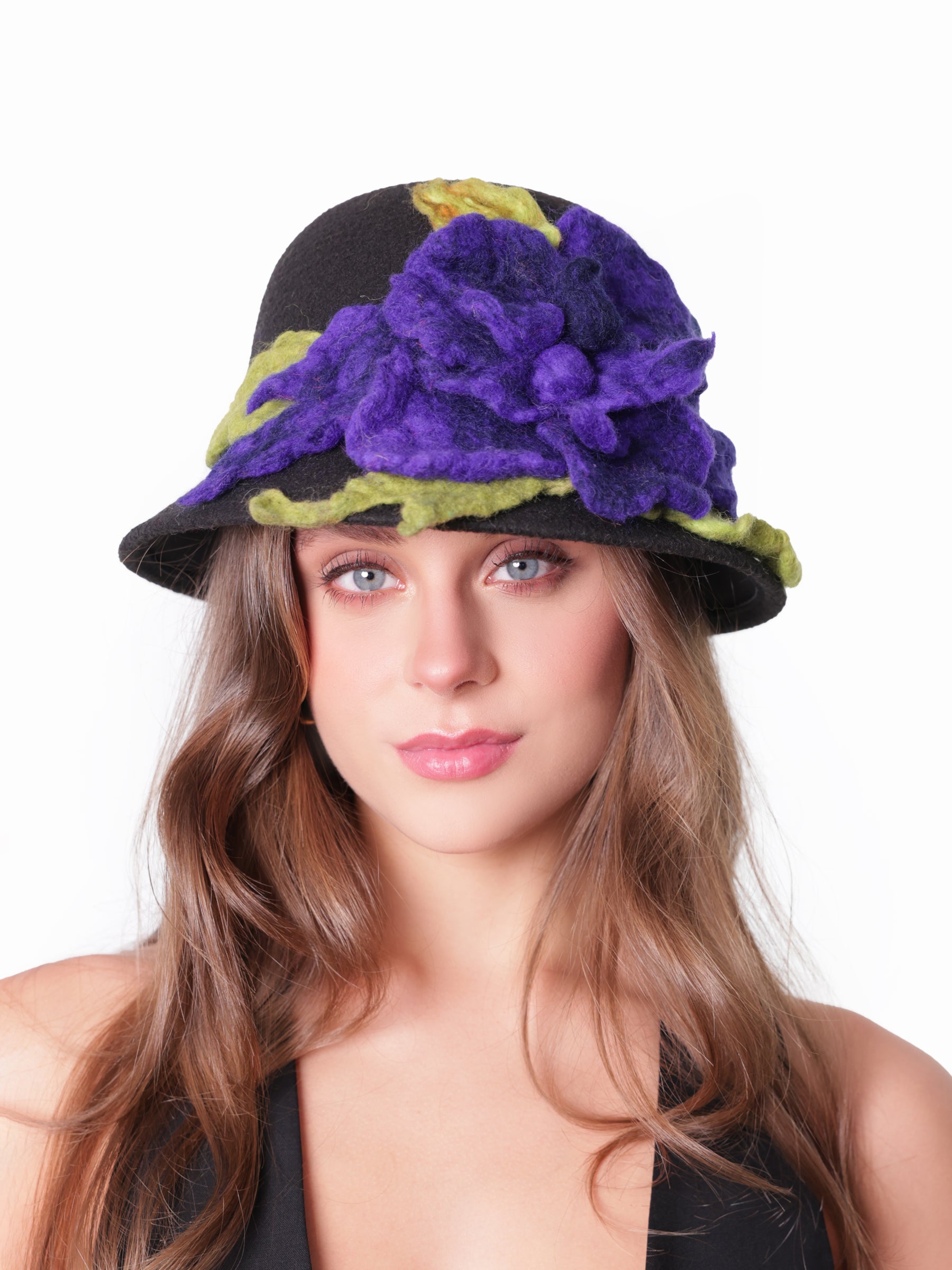 Model wearing a black cloche hat with handmade violet felt floral detail, front view.