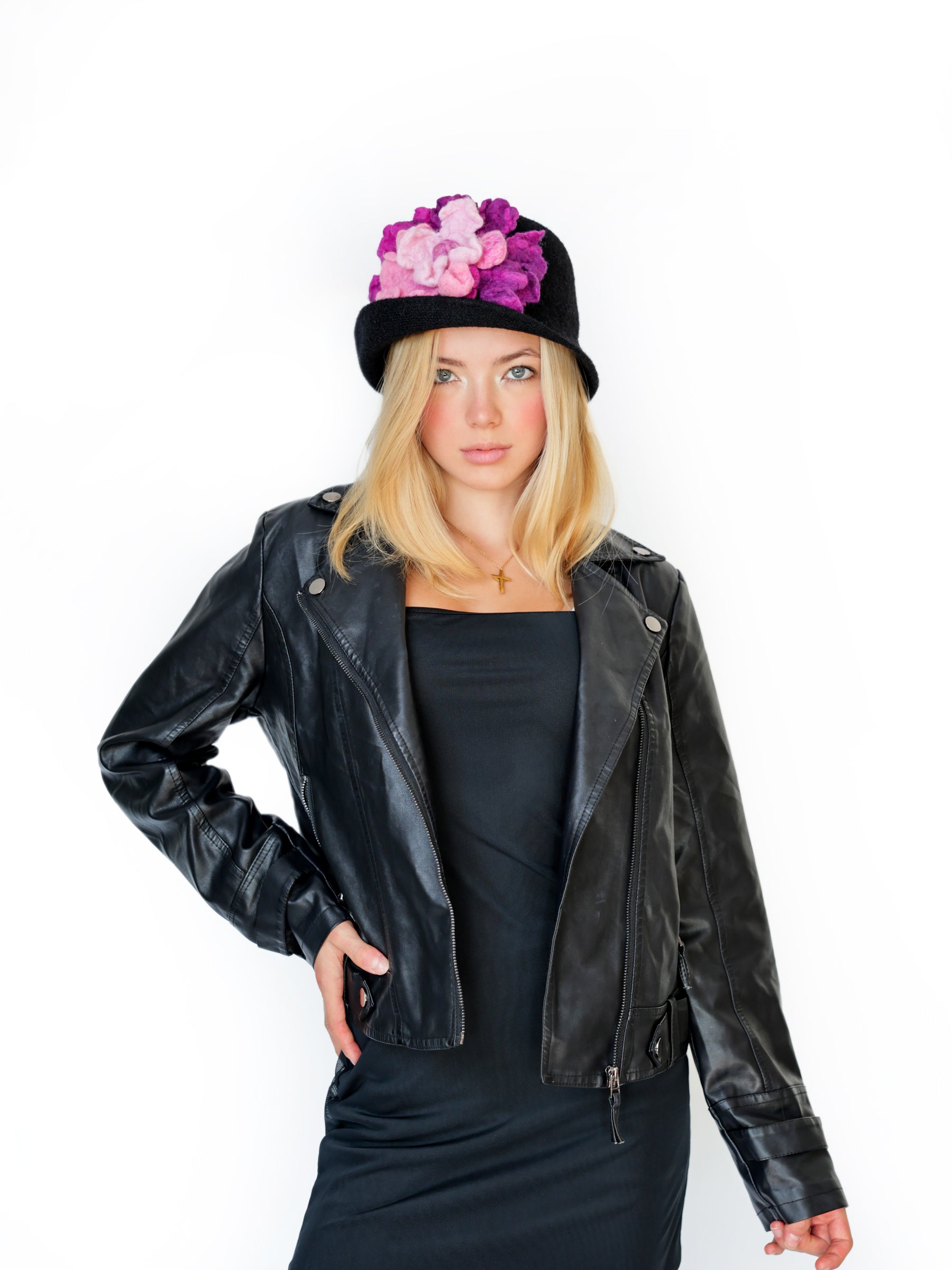 Model wearing a black cloche hat with handmade pink and purple felt floral detail, front view.