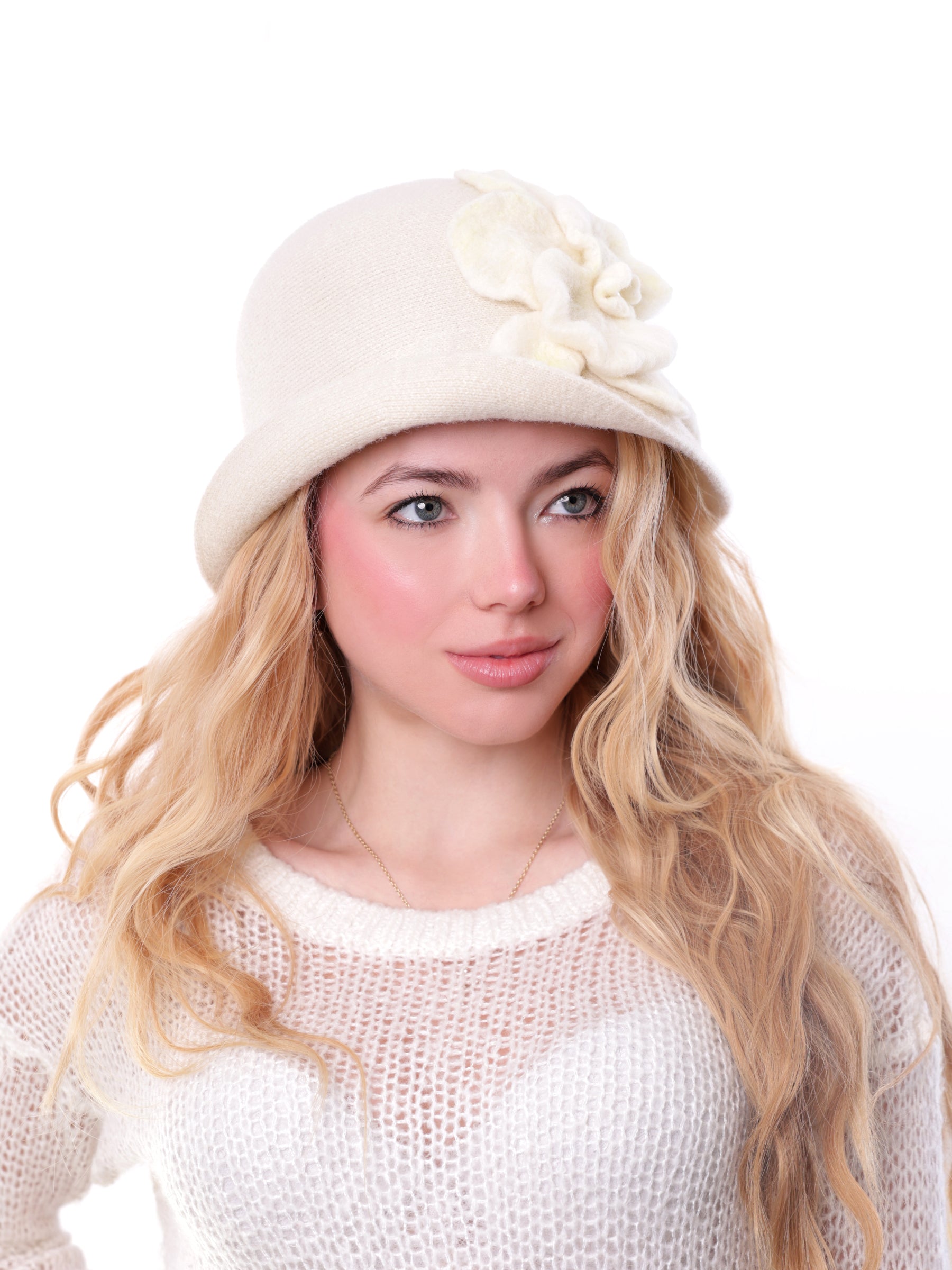 Side view of a woman wearing a handmade ivory-white wool cloche hat with a felt flower.