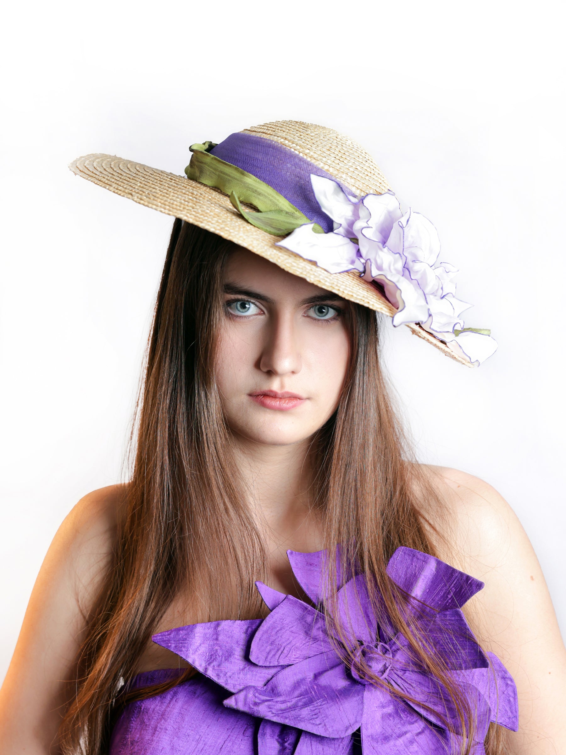 Front view of a straw summer hat with handmade satin flowers in white and lavender tones.