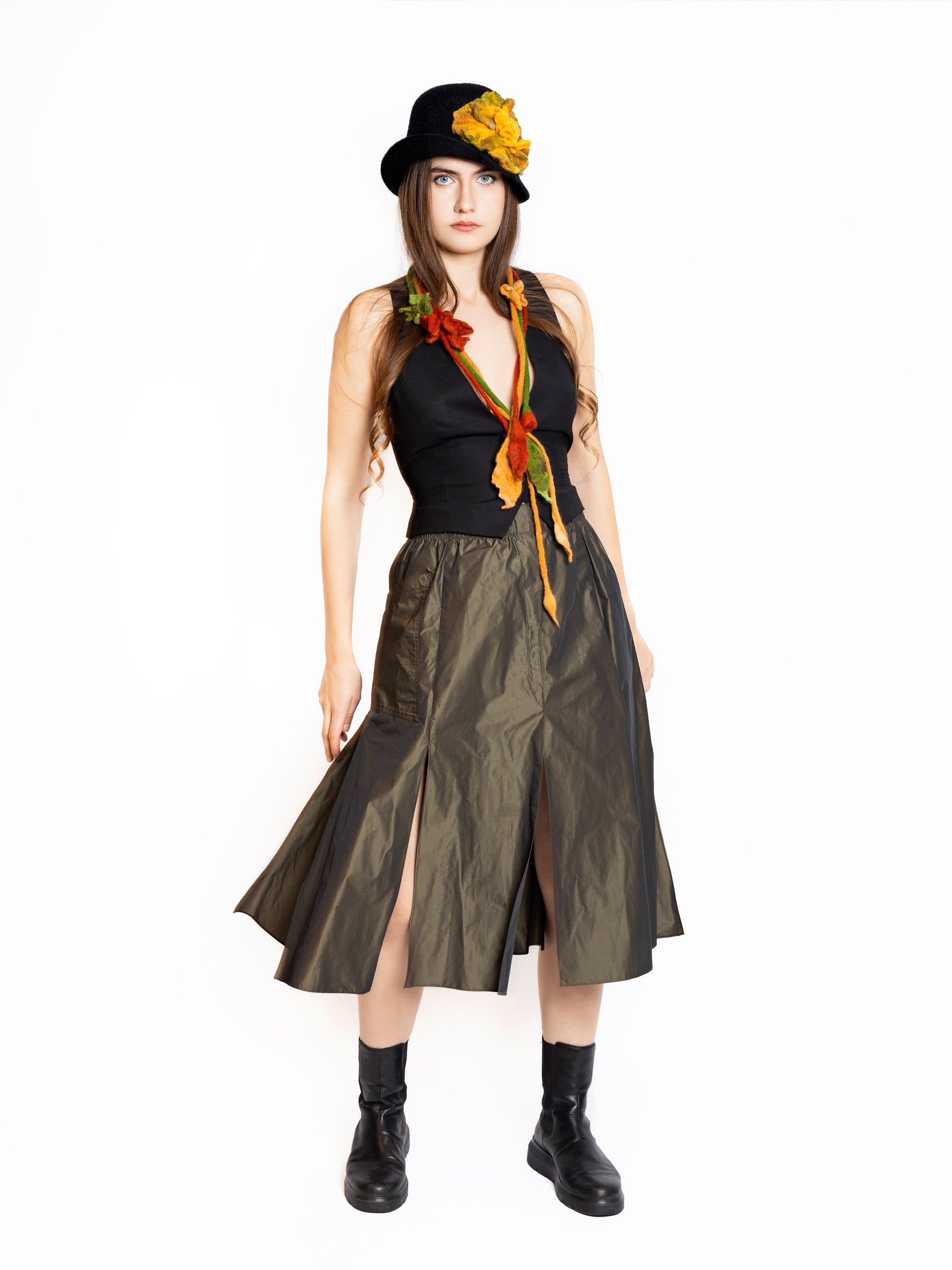 Woman wearing a metallic bronze midi skirt with a structured silhouette, styled for elegant daywear.