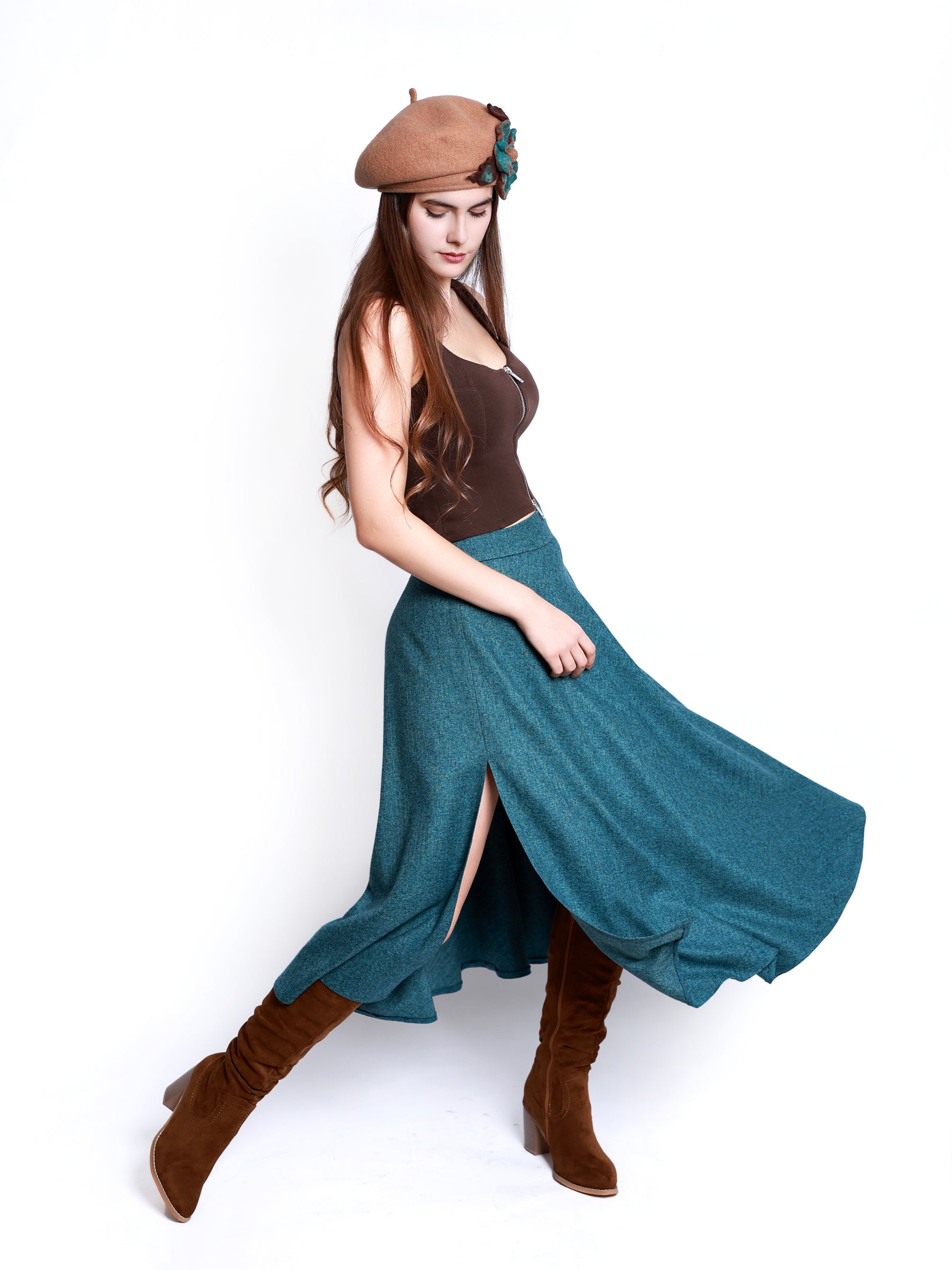 Angled view of a woman wearing a teal blue heather midi skirt with a fluid silhouette.